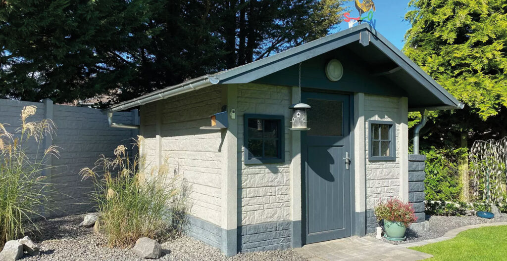 Modernes Betongartenhaus mit Fels-Motivplatte im Garten