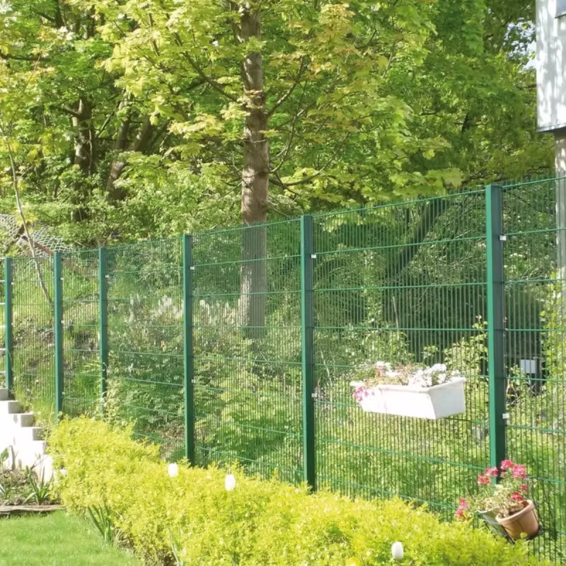 Grüner Doppelstabmattenzaun mit Rechteckpfosten entlang einer Gartengrenze, dahinter Bäume und Sträucher, davor eine niedrige Buchsbaumhecke
